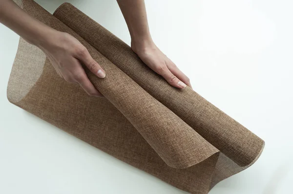 elinde kahverengi renk keten bir rulo