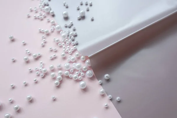 pembe arka plan üzerinde dağınık bir inci ile kağıt bir sayfa. Soyut yumuşak pastel renkler arka plan.
