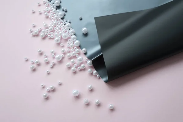 pembe arka plan üzerinde dağınık bir inci ile kağıt bir sayfa. Soyut yumuşak pastel renkler arka plan.