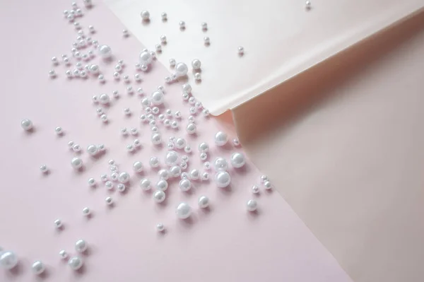 pembe arka plan üzerinde dağınık bir inci ile kağıt bir sayfa. Soyut yumuşak pastel renkler arka plan.