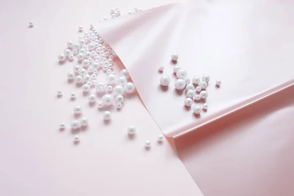 pembe arka plan üzerinde dağınık bir inci ile kağıt bir sayfa. Soyut yumuşak pastel renkler arka plan.