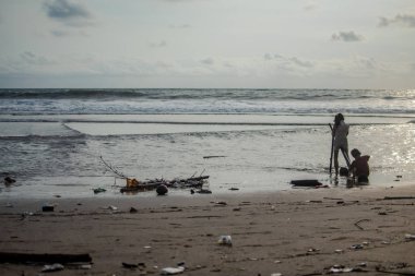 Çocuklar Hint Okyanusu kıyısındaki çöplerle oynuyorlar..