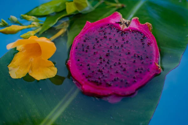 Dragón exótico fruta en el agua con hoja de grean y flor amarilla — Foto de Stock