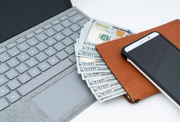 Laptop computer, cellphone and cash money
