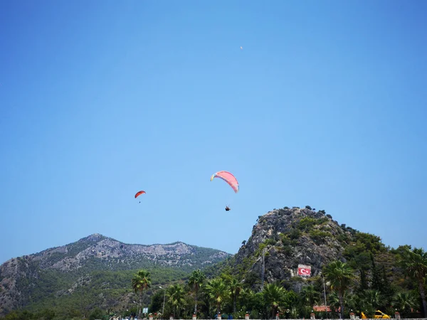 Parachuters yüksek yaz mavi gökyüzüne, Fethiye, Muğla yeşil bir tepe üzerinde uçan bir grup