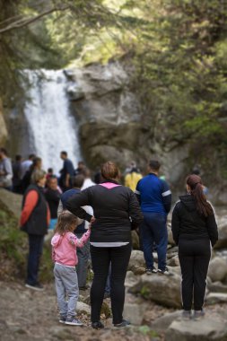 Pruncea Falls, Romania, 30th April 2019 - Group of tourists admire the beautiful waterfall clipart