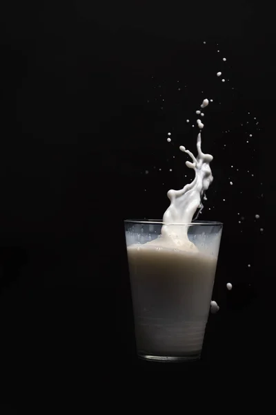 Milk glass splash isolated on black background — Stock Photo, Image