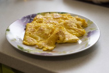 Peynir iç ve çok iyi kavrulmuş ile lezzetli kabarık omlette plaka bir mutfak önünde oturur
