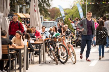 Bükreş, Romanya: 21.04.2019 - Sokak Gıda Kamyonu festivali. Sahipleri öğle yemeği yerken parkta bir gıda sokak festivalinde masa bisikletleri tarafından park