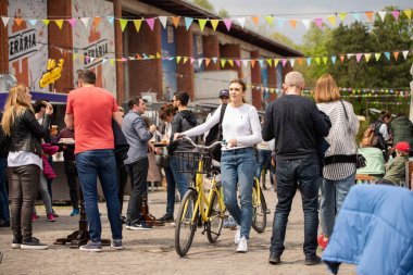 Bükreş, Romanya: 21.04.2019 - Sokak Gıda Kamyonu festivali - Kalabalığın ortasında parkta bir sokak gıda kamyon festivalinde bisiklet carrrying kız