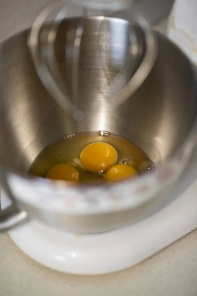 Кухонный передний с планетарным миксером с яичными белками и желтками в металлической чаше ждет, чтобы быть помешаны — стоковое фото