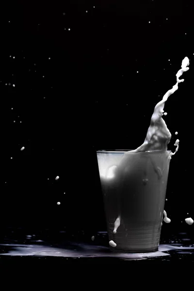 Mjölk glas stänk isolerad på svart bakgrund — Stockfoto