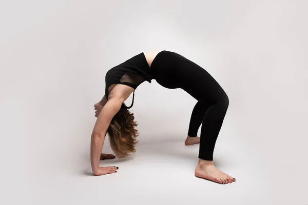 Flexible isolated blonde woman doing a bridge in yoga class — Stock Photo, Image