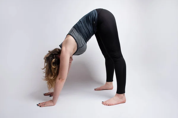 Down dog yoga pose done by flexible blonde woman — Stock Photo, Image