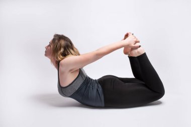 Sarışın kadın Bow Pose Dhanurasana yoga poz performans