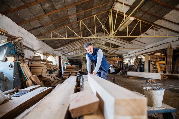 A man worker in the carpentry workshop, working with wood. — Stock Photo, Image