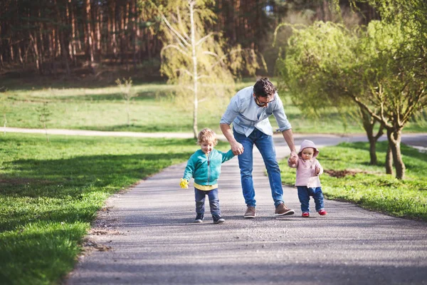 Батько з маленькими дітьми на весняній прогулянці . — стокове фото