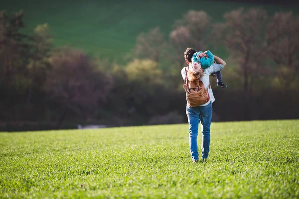 Un padre con su hijo pequeño en un paseo fuera en la naturaleza de primavera . —  Fotos de Stock