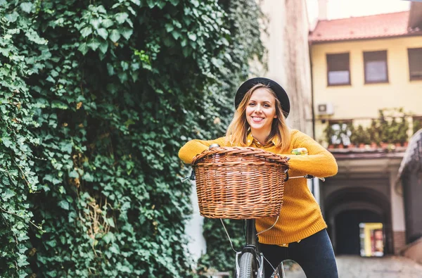 Junge Frau mit Fahrrad in sonniger Frühlingsstadt. — Stockfoto