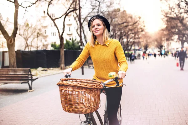 Nuori nainen ratsastus polkupyörällä aurinkoisessa kevätkaupungissa . — kuvapankkivalokuva