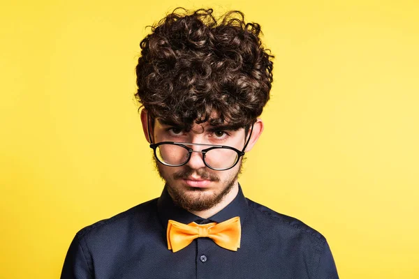 Portret van een jonge man in een studio op een gele achtergrond. — Stockfoto