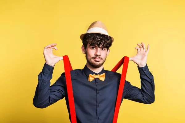 Portret van een jonge man in een studio op een gele achtergrond. — Stockfoto