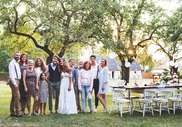 Novia, novio, invitados posando para la foto en la recepción de la boda en el patio trasero . —  Fotos de Stock