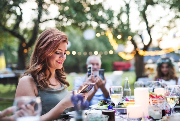 Gäste mit Smartphones fotografieren bei Hochzeitsfeier draußen. — Stockfoto