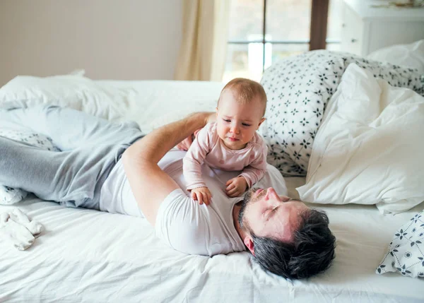 Vater mit Kleinkind im Bett zu Hause vor dem Schlafengehen. — Stockfoto