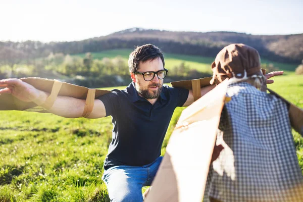 Glada barnet pojke spelar utanför med far i vår natur. — Stockfoto