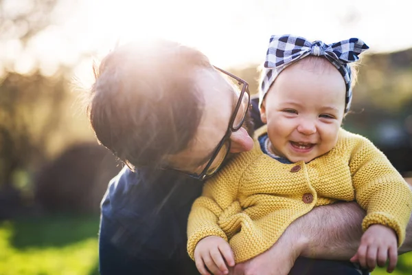 Um pai com sua filha criança lá fora na natureza primavera . — Fotografia de Stock