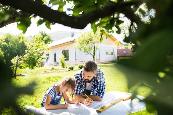 Father with a small daughter outside, planning wooden birdhouse. — Stock Photo, Image