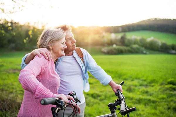 Bella coppia anziana con biciclette all'aperto nella natura primaverile . — Foto Stock