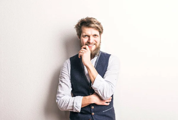 Portrait of a young hipster man in a studio, laughing. Copy space. — Stock Photo, Image