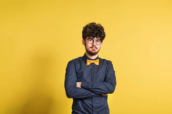 Portret van een jonge man in een studio op een gele achtergrond. — Stockfoto