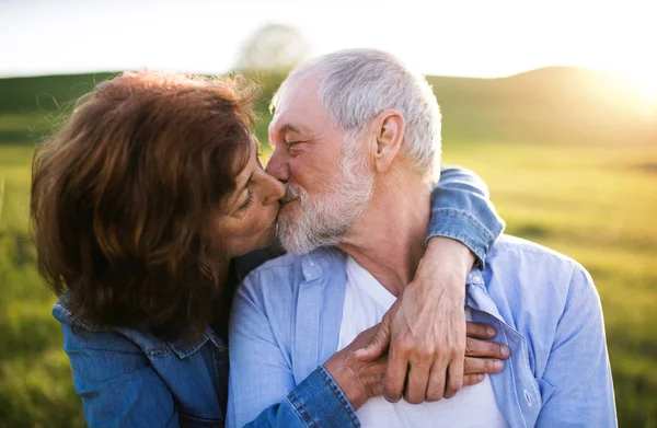 Pareja mayor afuera en la naturaleza de primavera, besándose . — Foto de Stock