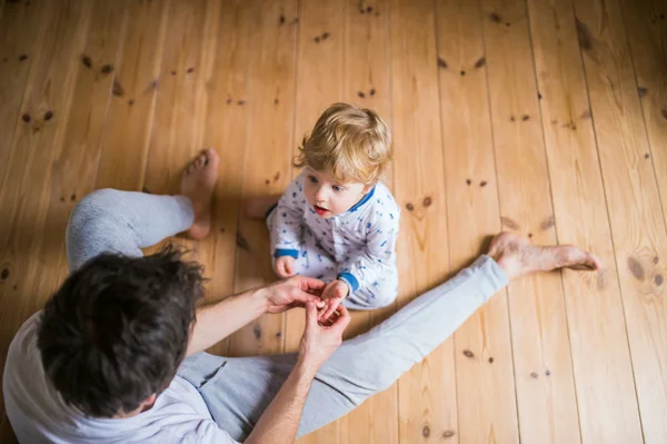 Ayah dengan anak balita duduk di lantai di kamar tidur di rumah. Tampilan atas . — Stok Foto