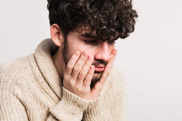 Porträtt av en ung man i ull kofta i en studio. — Stockfoto