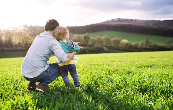 En far med sin toddler son utanför i vår natur. Kopiera utrymme. — Stockfoto