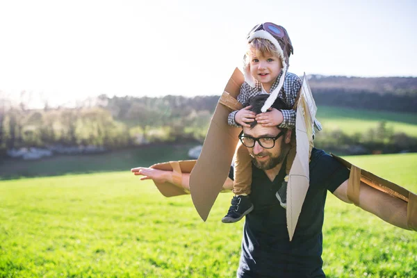 Ευχαρίστως toddler αγόρι και ο πατέρας παίζει με φτερά έξω στη φύση την άνοιξη. — Φωτογραφία Αρχείου