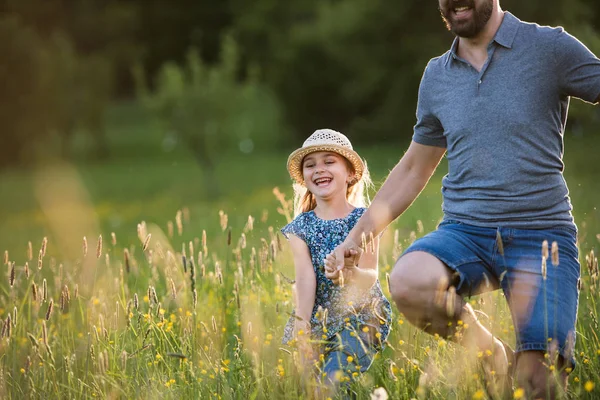 Father with a small daughter running in spring nature. — Stock Photo, Image