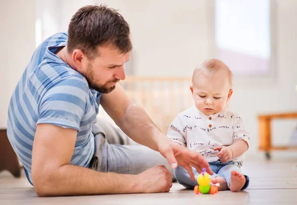 Mladý otec, hrát si s malým synkem doma. — Stock fotografie