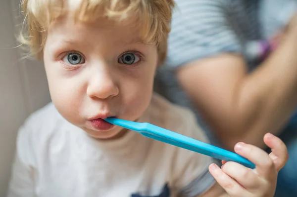 A happy toddler boy brushing his teeth at home. Close up. — Stock Photo, Image