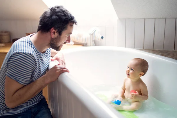 Padre lavando a un niño en el baño en casa . — Foto de Stock