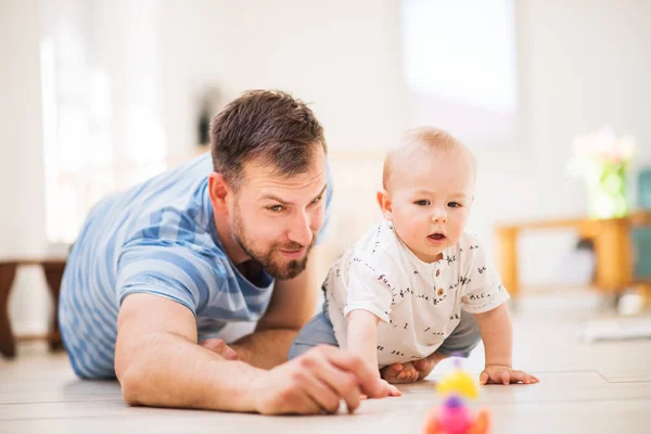 Evde bir bebek evlat ile oynayan genç baba. — Stok fotoğraf