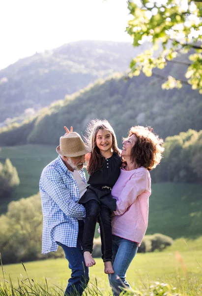 Äldre par med barnbarn utanför i våren naturen, koppla av och ha roligt. — Stockfoto