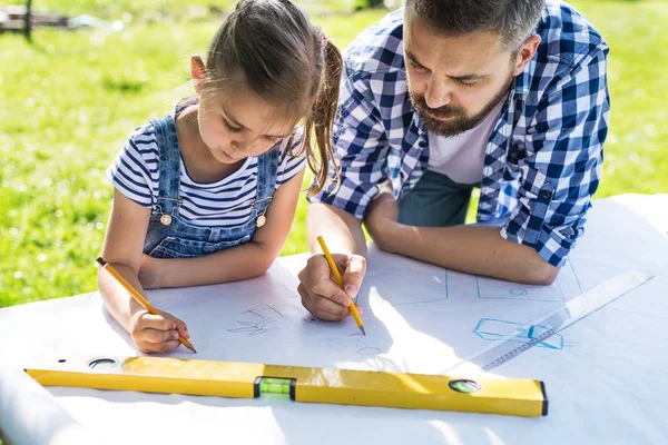 Father with a small daughter outside, planning wooden birdhouse. — Stock Photo, Image