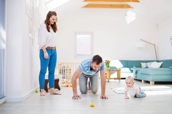 Jeune famille jouant avec un bébé garçon à la maison . — Photo