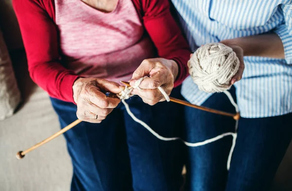 Неузнаваемая пожилая бабушка и взрослая внучка дома, вязание . — стоковое фото