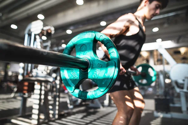 Passar ung man i gymmet träna, lyfta skivstång. — Stockfoto